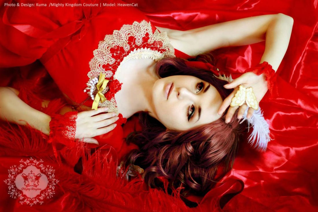 Model mit rotem Spitzen Kleid auf rotem Satin