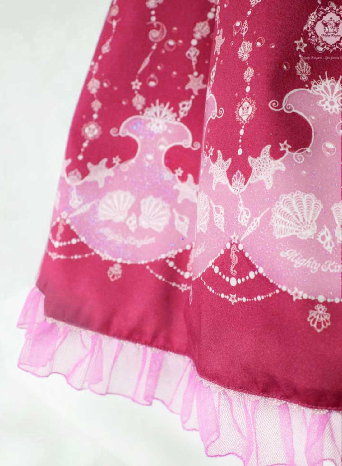 Detailansicht des Stoffmusters des Magical Sea World Kleides in rosa-rot mit Glitzer